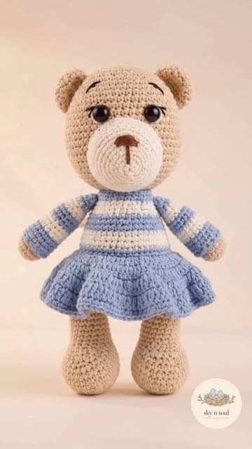 Crochet bear toy in a blue and white striped dress