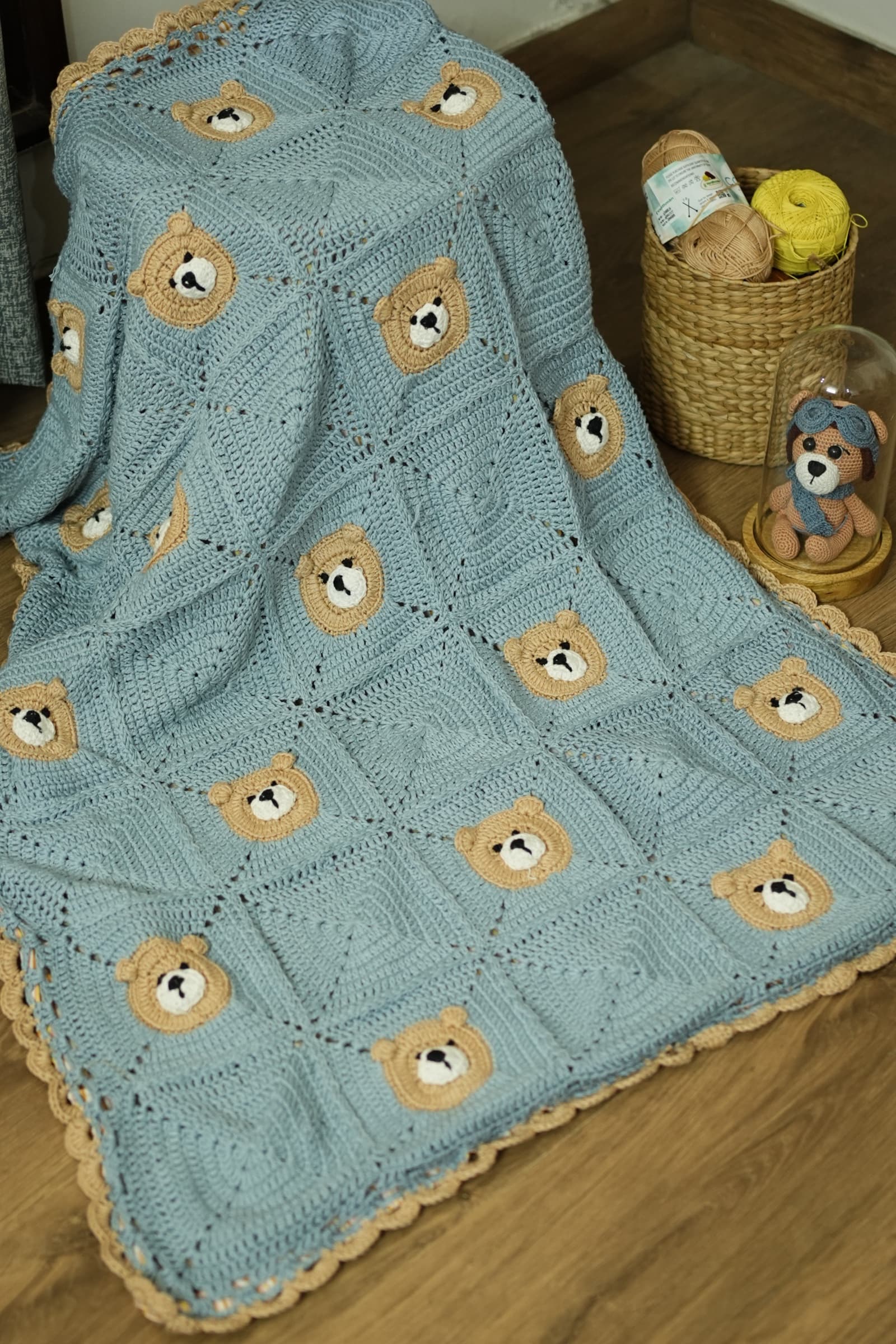 Baby wrapped in Tiny Paws light blue crochet blanket with beige bear appliqués